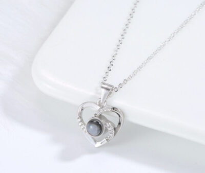 Love Link silver necklace featuring interlocking hearts with luminous pearl centre